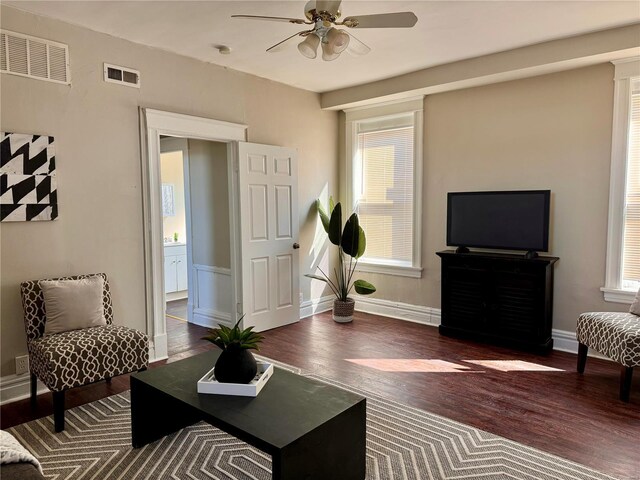 living room with a healthy amount of sunlight, ceiling fan, and dark hardwood / wood-style flooring