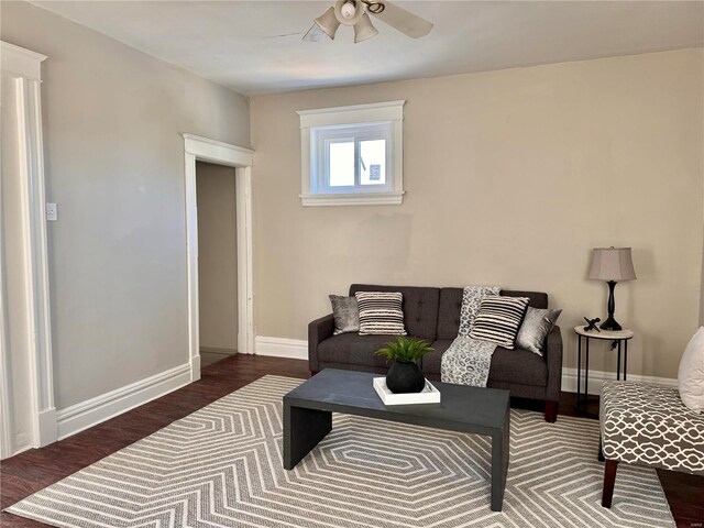 living room featuring ceiling fan and dark hardwood / wood-style flooring