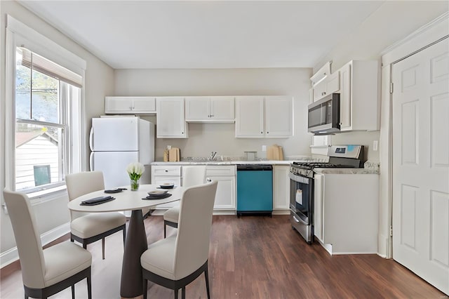 kitchen with sink, appliances with stainless steel finishes, dark hardwood / wood-style flooring, and white cabinets