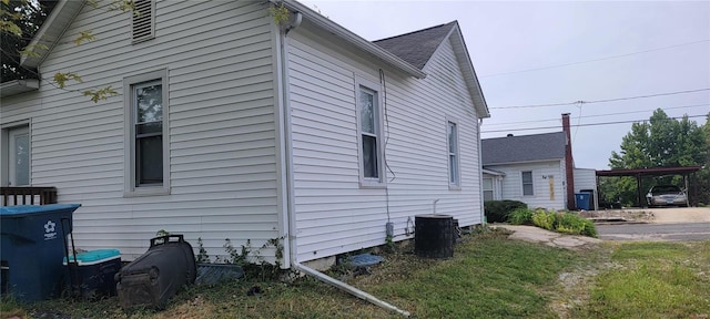 view of side of home with cooling unit and a carport