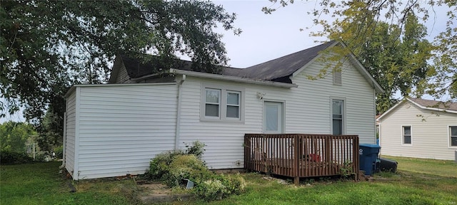 rear view of property with a lawn and a wooden deck