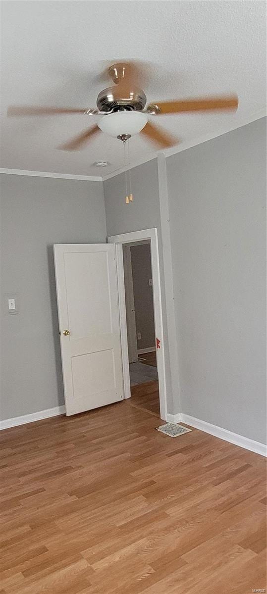 spare room featuring a textured ceiling, ceiling fan, and light wood-type flooring