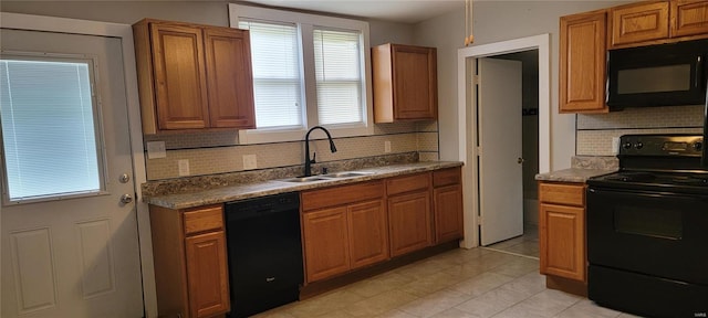 kitchen featuring black appliances, sink, light tile patterned floors, and tasteful backsplash