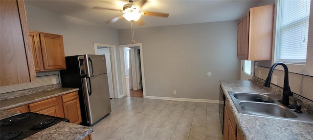 kitchen featuring tasteful backsplash, stainless steel refrigerator, sink, and ceiling fan