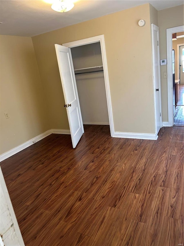 unfurnished bedroom featuring a closet and dark hardwood / wood-style flooring