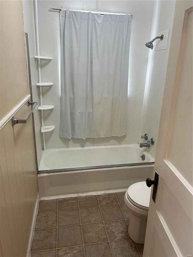 bathroom featuring toilet, bath / shower combo with glass door, and tile patterned floors