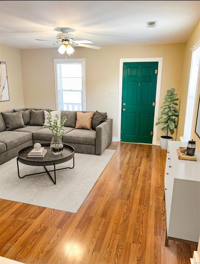 living room featuring ceiling fan and light hardwood / wood-style floors