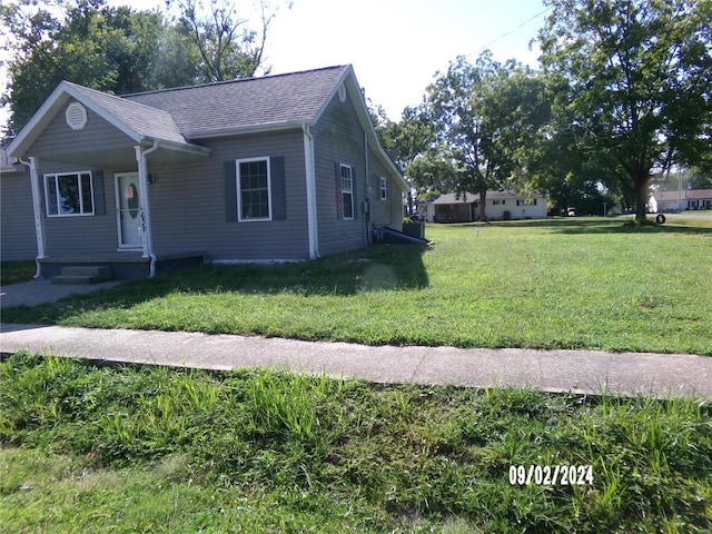 view of side of home with a yard