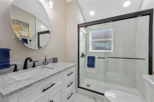 bathroom featuring vanity, toilet, and a shower with shower door