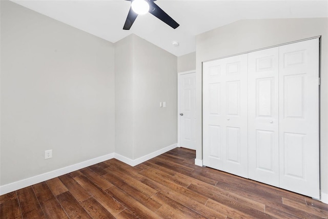 unfurnished bedroom with dark wood-type flooring, lofted ceiling, ceiling fan, and a closet