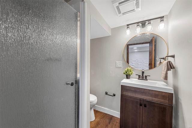 bathroom featuring vanity, toilet, an enclosed shower, and hardwood / wood-style flooring