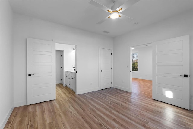 unfurnished bedroom featuring connected bathroom, ceiling fan, and light wood-type flooring