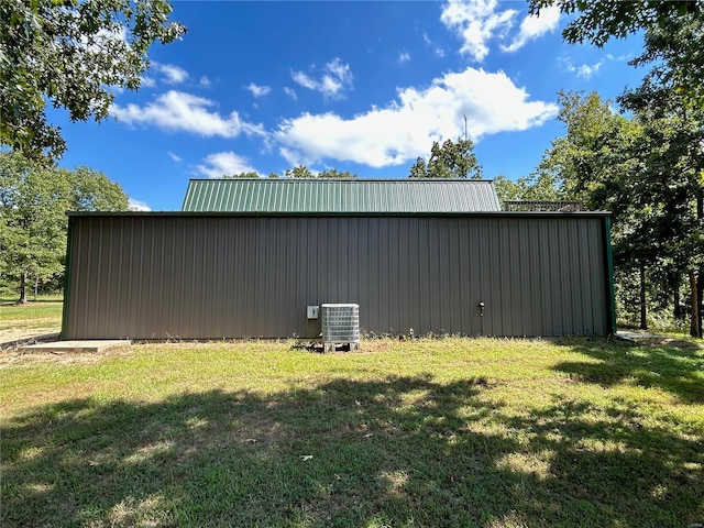 view of outdoor structure featuring a yard and cooling unit