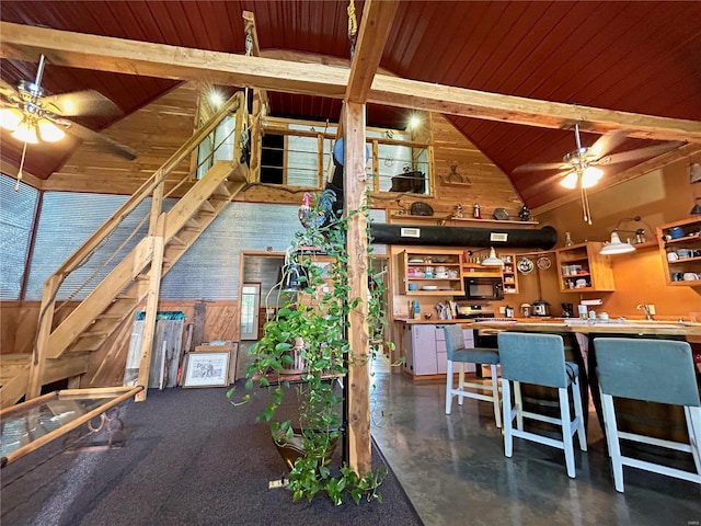 interior space featuring wooden ceiling, high vaulted ceiling, beam ceiling, and ceiling fan