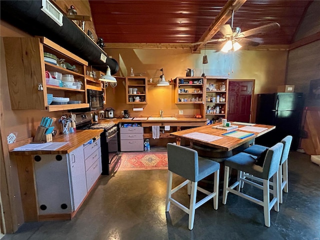 kitchen with concrete floors, wooden ceiling, black appliances, ceiling fan, and beam ceiling