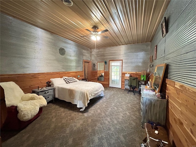 bedroom with carpet flooring, ceiling fan, wood walls, and wooden ceiling