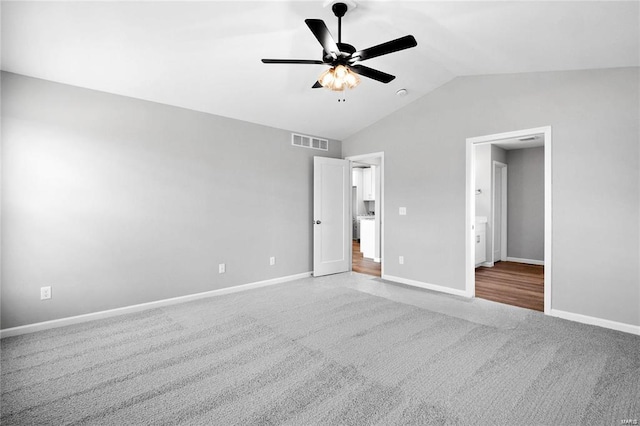 unfurnished bedroom featuring lofted ceiling, ceiling fan, and light carpet