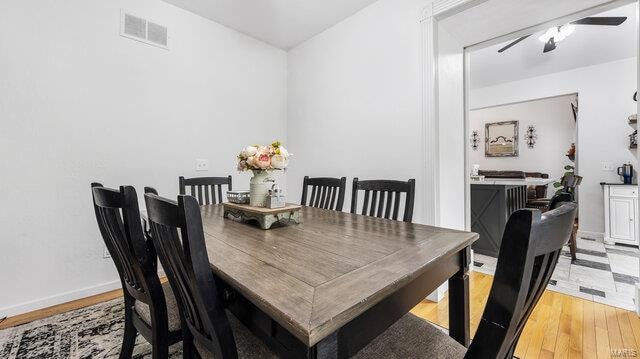 dining space with light wood-style floors, visible vents, and baseboards