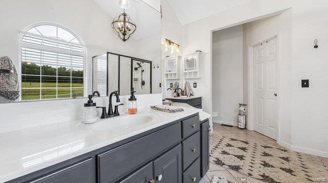 bathroom featuring a stall shower, lofted ceiling, an inviting chandelier, tile patterned flooring, and vanity