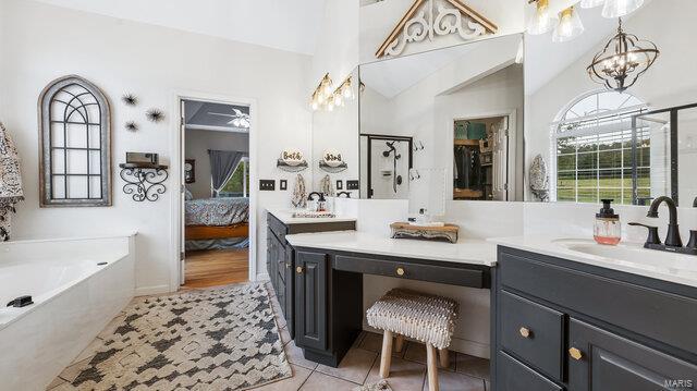 bathroom featuring vanity, plus walk in shower, and tile patterned flooring