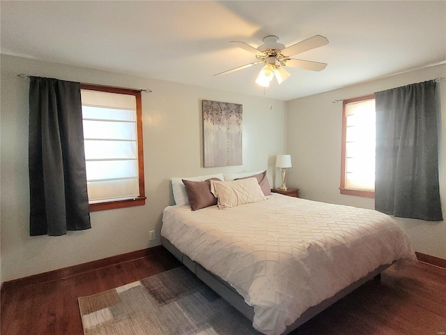 bedroom featuring ceiling fan, baseboards, and wood finished floors