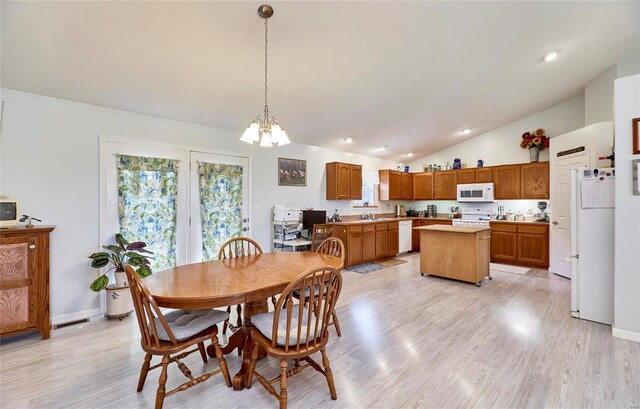 dining area featuring light wood-type flooring, lofted ceiling, and a chandelier