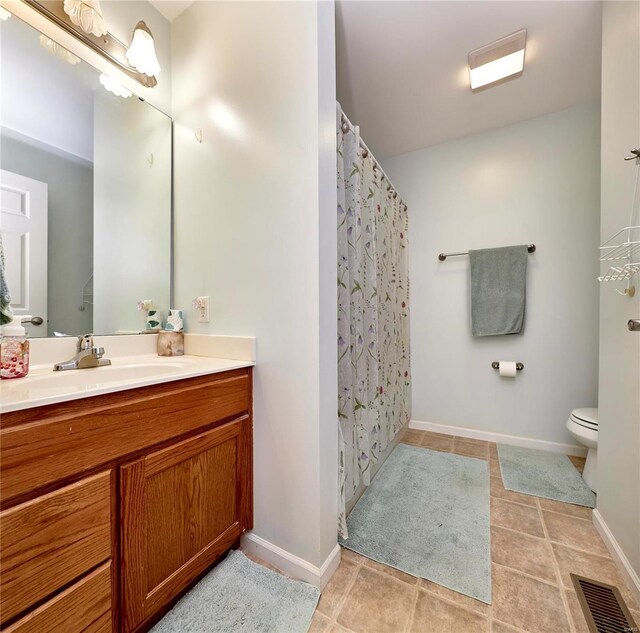 bathroom with tile patterned flooring, vanity, and toilet