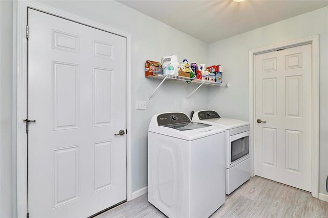 laundry area featuring independent washer and dryer and light hardwood / wood-style flooring