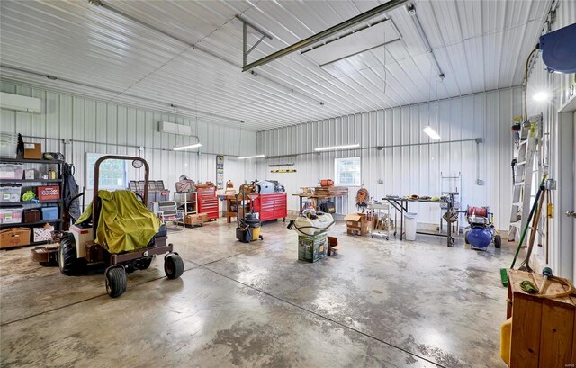 garage with an AC wall unit and a workshop area