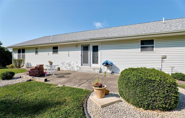 rear view of house featuring a patio and a yard