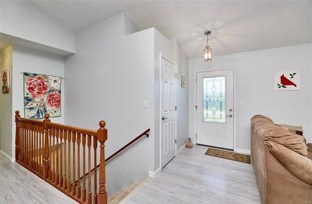 entrance foyer featuring vaulted ceiling and light hardwood / wood-style flooring