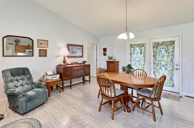 dining room with lofted ceiling, an inviting chandelier, and light hardwood / wood-style flooring