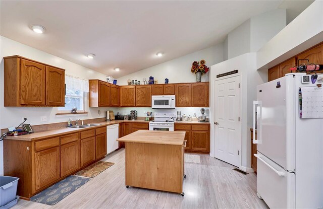 kitchen with light hardwood / wood-style floors, a center island, sink, lofted ceiling, and white appliances