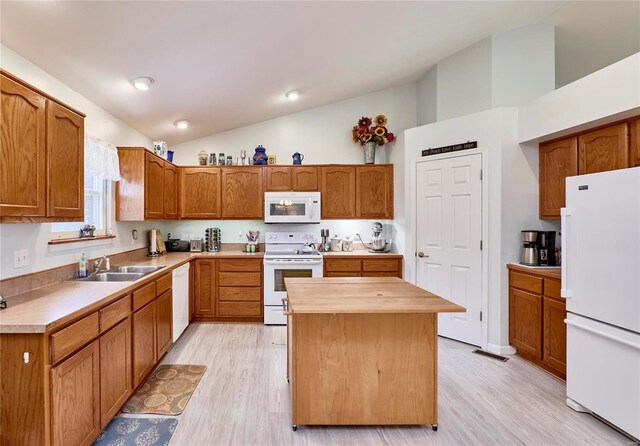 kitchen featuring light hardwood / wood-style floors, white appliances, a kitchen island, lofted ceiling, and sink