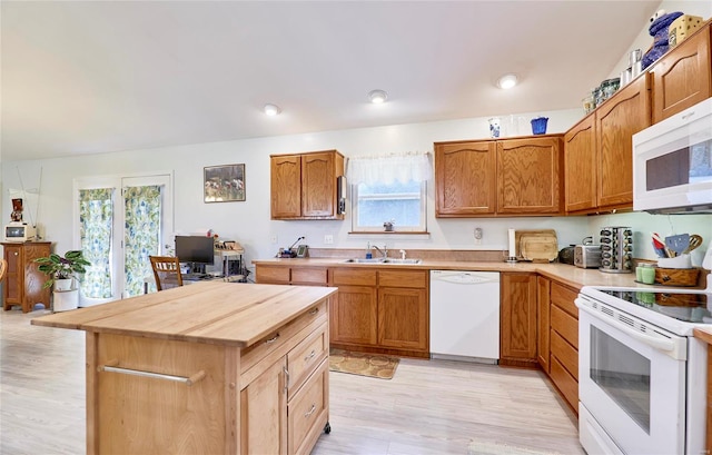 kitchen featuring light hardwood / wood-style flooring, a wealth of natural light, white appliances, and sink