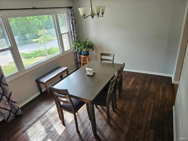 dining space with a notable chandelier and dark hardwood / wood-style floors