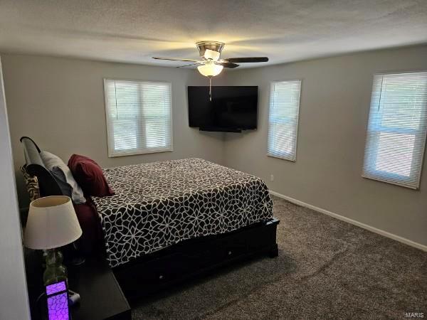 carpeted bedroom featuring a textured ceiling and ceiling fan