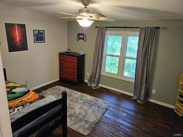 bedroom with dark hardwood / wood-style flooring and ceiling fan