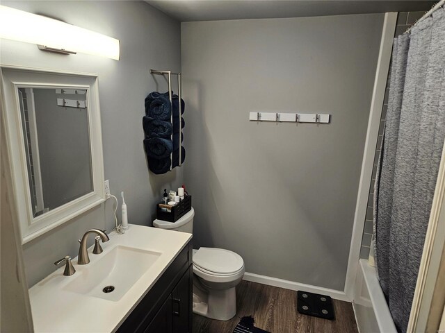 full bathroom with wood-type flooring, toilet, shower / tub combo with curtain, and vanity