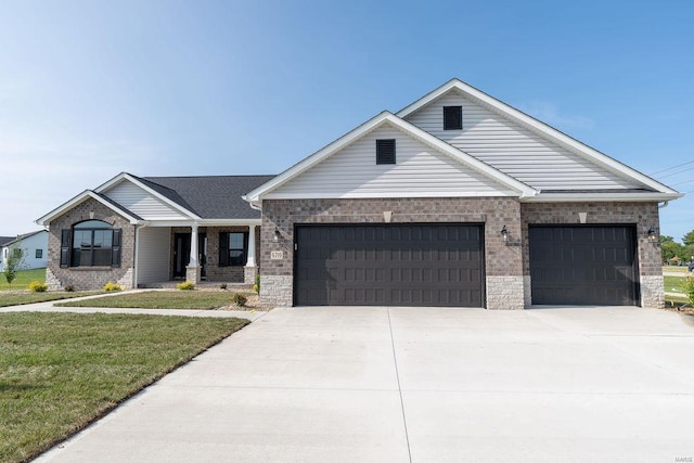 view of front of house featuring a garage, a front yard, brick siding, and driveway