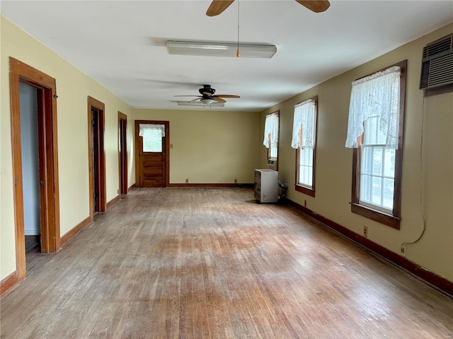 unfurnished living room with light wood-style floors, plenty of natural light, and baseboards