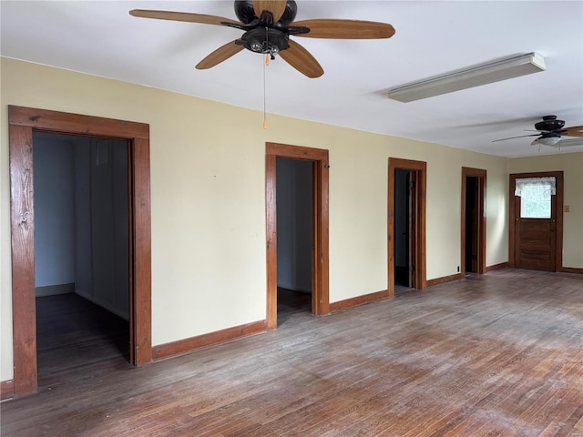 spare room with ceiling fan, baseboards, and wood finished floors