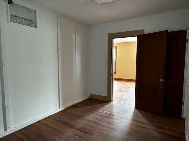 unfurnished room with wood finished floors and baseboards