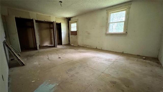 interior space with a textured ceiling and a healthy amount of sunlight