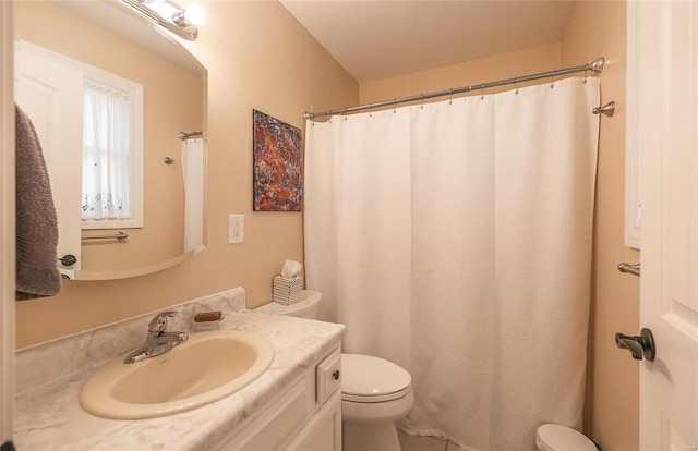 bathroom featuring toilet, curtained shower, and vanity