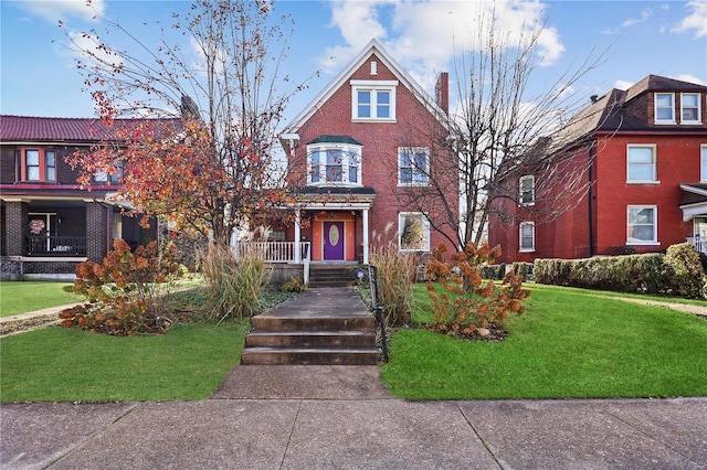 victorian-style house with a front lawn and a porch