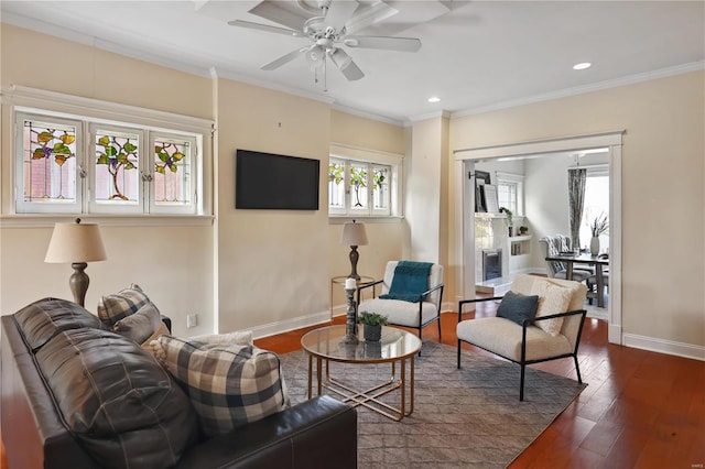 living room with dark hardwood / wood-style floors, ceiling fan, and crown molding