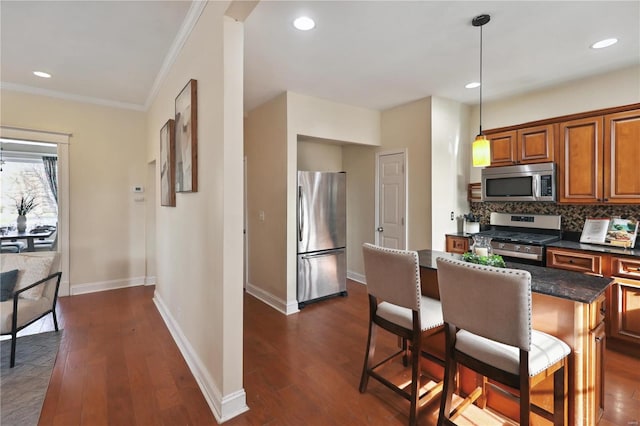 kitchen with a center island, dark hardwood / wood-style flooring, stainless steel appliances, and hanging light fixtures