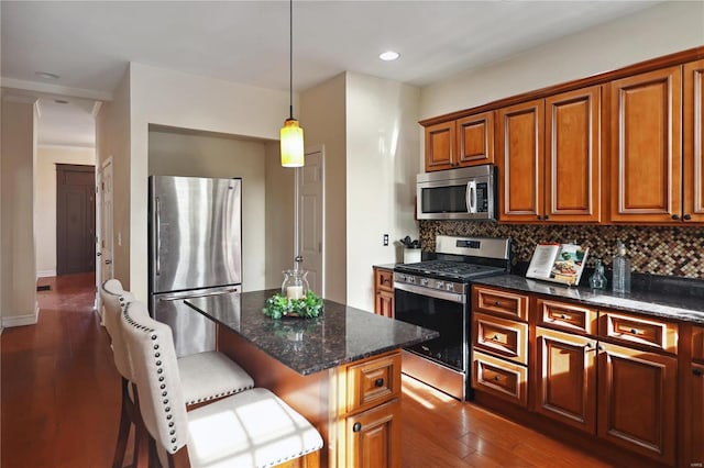 kitchen with backsplash, dark wood-type flooring, a kitchen breakfast bar, appliances with stainless steel finishes, and a kitchen island