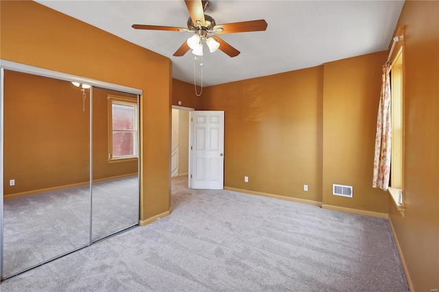 unfurnished bedroom with ceiling fan, a closet, and light colored carpet